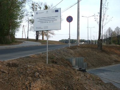 Przebudowa ul. Karbowej w Bielsku-Białej - na zdjęciu fragment drogi, znak drogowy, tablica informacyjna oraz drzewa