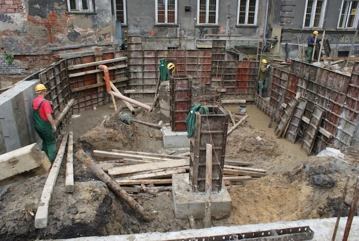 Budowa sali gimnastycznej - na zdjęciu fragment budowy, pracownicy oraz budynek w tle