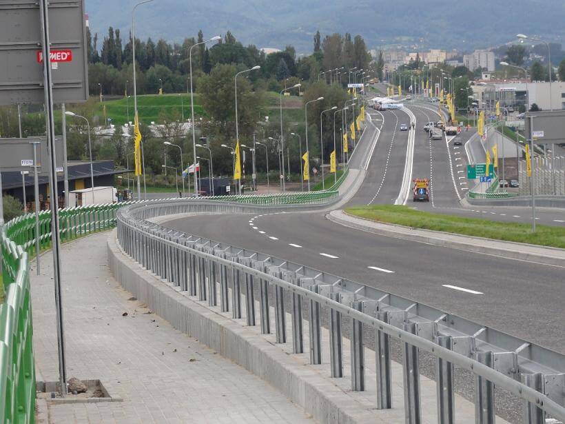 Przebudowa odcinka drogi krajowej nr 52 - na zdjęciu fragment drogi, budynki oraz zieleń