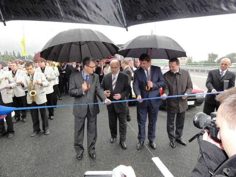 Przebudowa odcinka drogi krajowej nr 52 - na zdjęciu uroczyste przecięcie wstęgi przez delegatów w towarzystwie orkiestry i reportera