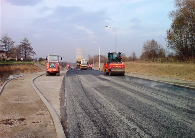 Budowa ul. Sarni Potok w Bielsku-Białej - na zdjęciu budowa drogi, maszyny budowlane oraz zieleń