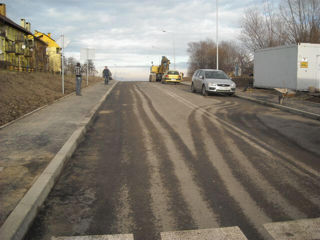 Budowa ul. Sarni Potok w Bielsku-Białej - na zdjęciu fragment drogi, blok mieszkalny oraz samochody
