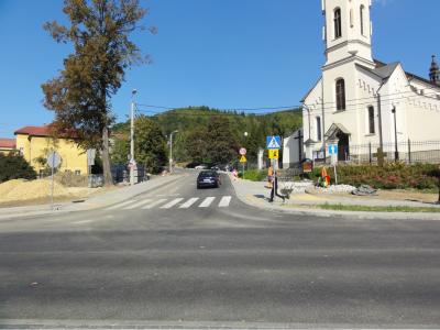 Zdjęcie przedstawiające przejście dla pieszych prowadzące do kościoła przy drodze.