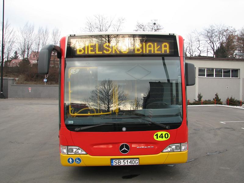 Zakupione autobusy niskopodłogowe marki Mercedes - na zdjęciu autobus oraz budynki