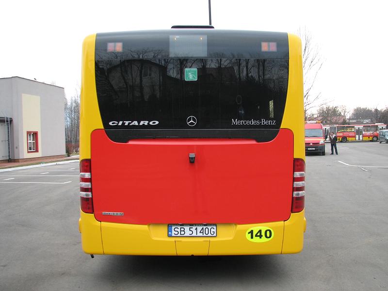 Zakupione autobusy niskopodłogowe marki Mercedes - na zdjęciu tył autobusu, pojazd oraz budynek