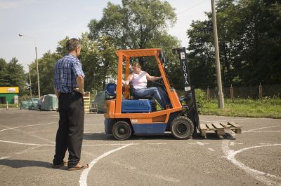 zdjęcie osoby uczącej się jazdy wózkiem widłowym pod nadzorem instruktora