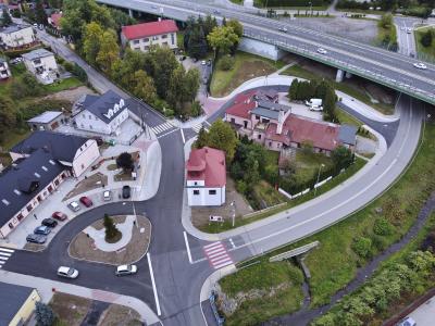 Zdjęcie przedstawiające skrzyżowanie z wjazdem na estakadę, widziane z lotu ptaka, w otoczeniu zabudowy mieszkalnej.