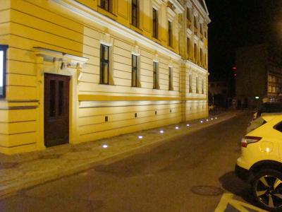 Zdjęcie przedstawiające oświetloną elewację budynku Teatru Polskiego w Bielsku-Białej oraz ulice obok budynku nocą.