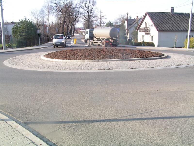 Przebudowa ul. Bestwińskiej w Bielsku-Białej - na zdjęciu fragment drogi z rondem, pojazdy, budynki oraz zieleń