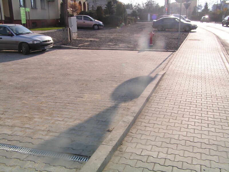 Przebudowa ul. Bestwińskiej w Bielsku-Białej - na zdjęciu fragment chodnika, pojazdy oraz budynki