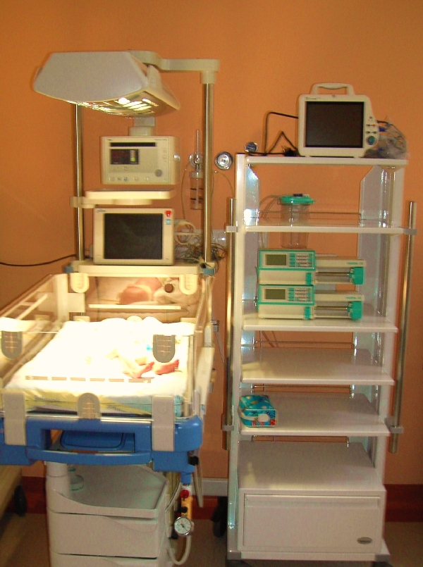 na zdjęciu stanowisko do intensywnej opieki nad noworodkiem z inkubatorem i aparaturą medyczną