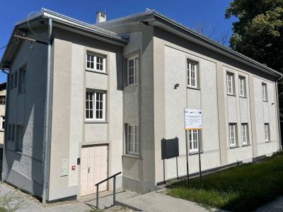 Zdjęcie przedstawiające dwukondygnacyjny budynek o jasnej elewacji.