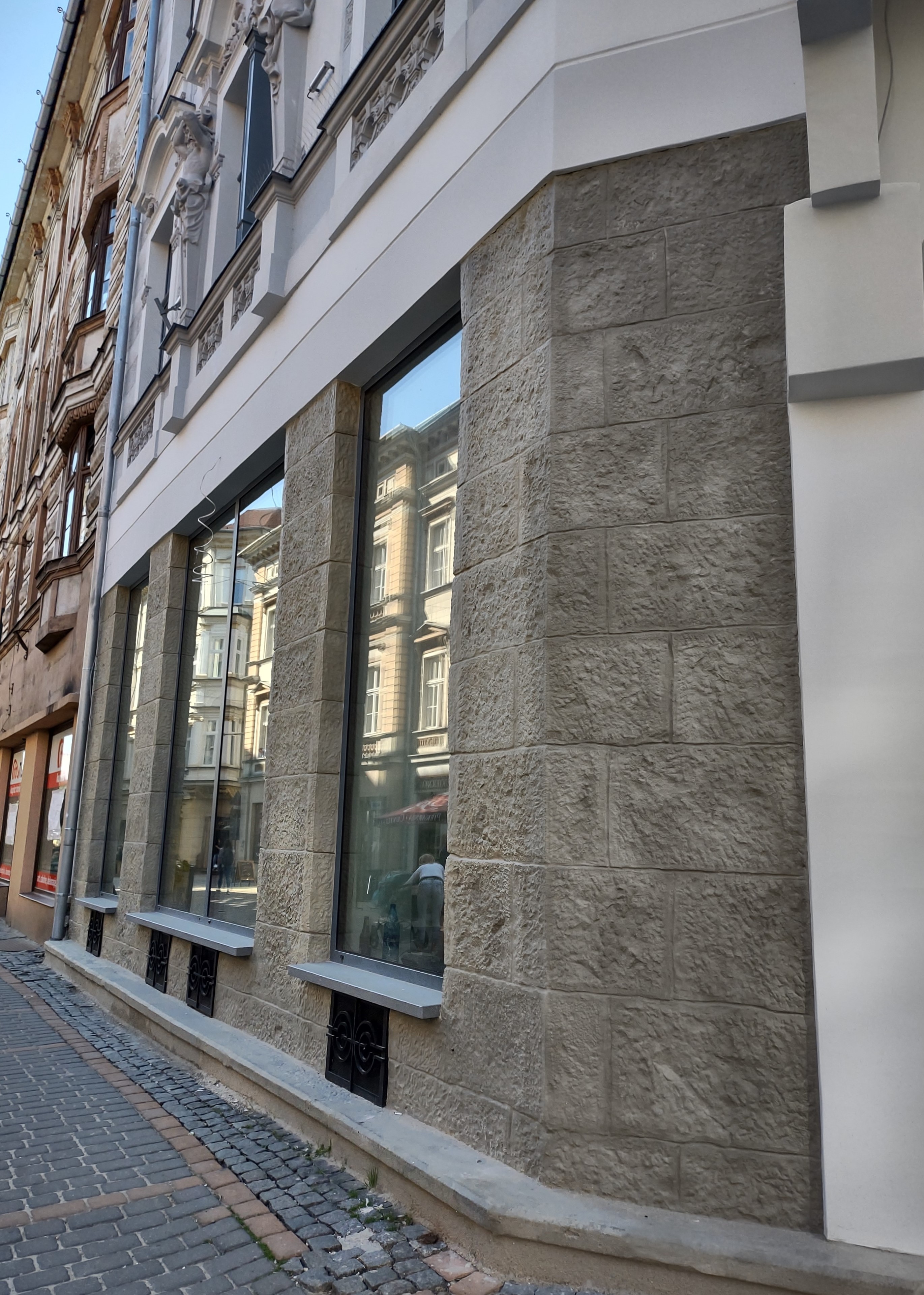 Barlickiego 4 widok elewacji z pasem witryn oraz kamienną okładziną w parterze po konserwacji. 