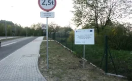 Przebudowa ul. Karbowej w Bielsku-Białej - na zdjęciu fragment drogi, znaki drogowe, tablica informacyjna oraz zieleń