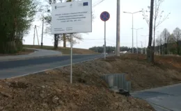 Przebudowa ul. Karbowej w Bielsku-Białej - na zdjęciu fragment drogi, znak drogowy, tablica informacyjna oraz drzewa