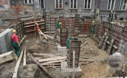 Budowa sali gimnastycznej - na zdjęciu fragment budowy, pracownicy oraz budynek w tle