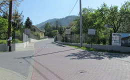 Przebudowa ul. Ks. Brzóski w Bielsku-Białej - na  zdjęciu fragment drogi, znak drogowy, tablice informacyjne oraz budynek budynek