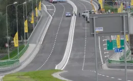 Przebudowa odcinka drogi krajowej nr 52 - na zdjęciu fragment drogi, budynki, pojazdy oraz zieleń