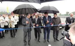 Przebudowa odcinka drogi krajowej nr 52 - na zdjęciu uroczyste przecięcie wstęgi przez delegatów w towarzystwie orkiestry i reportera