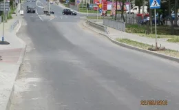 Przebudowa drogi krajowej 69 - na zdjęciu fragment drogi, znak drogowy, reklamy, budynki oraz pojazdy