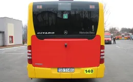 Zakupione autobusy niskopodłogowe marki Mercedes - na zdjęciu tył autobusu, pojazd oraz budynek