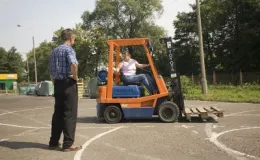 zdjęcie osoby uczącej się jazdy wózkiem widłowym pod nadzorem instruktora