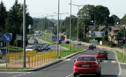 Droga wojewódzka nr 942 w Bielsku-Białej - na zdjęciu fragment drogi, znaki drogowe, świetlenie, pojazdy, budynki oraz zieleń