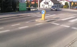 Przebudowa ul. Bestwińskiej w Bielsku-Białej- na zdjęciu fragment drogi, znak drogowy, pojazd oraz budynki