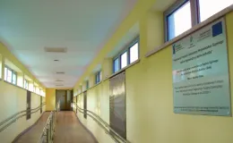 na zdjęciu jasny korytarz z pochylnią i tablicą informacyjną o dofinansowaniu z UE