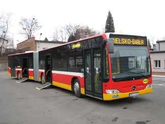 Zakupione autobusy niskopodłogowe marki Mercedes - na zdjęciu autobus oraz budynki 
