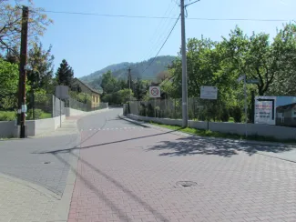 Przebudowa ul. Ks. Brzóski w Bielsku-Białej - na  zdjęciu fragment drogi, znak drogowy, tablice informacyjne oraz budynek budynek