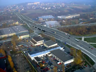 Przebudowa odcinka drogi krajowej nr 52 - na zdjęciu fragment drogi, budynki oraz zieleń