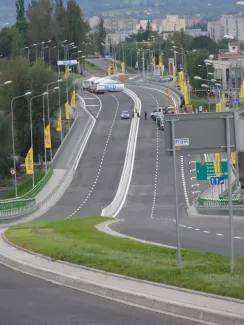 Przebudowa odcinka drogi krajowej nr 52 - na zdjęciu fragment drogi, budynki, pojazdy oraz zieleń