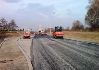 Budowa ul. Sarni Potok w Bielsku-Białej - na zdjęciu budowa drogi, maszyny budowlane oraz zieleń