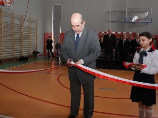 Otwarcie sali gimnastycznej - na zdjęciu Prezydent Miasta przecina wstęgę w towarzystwie uczennicy i zgromadzonych gości