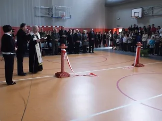 Otwarcie sali gimnastycznej - na zdjęciu przemawiający duchowny wśród zgromadzonej publiczości