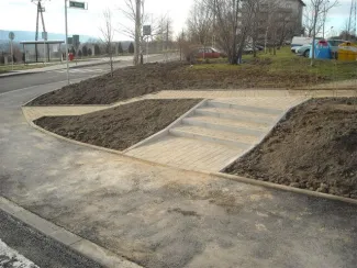 Budowa ul. Sarni Potok w Bielsku-Białej - na zdjęciu fragment drogi, chodnik, schody, blok mieszkalny oraz zieleń