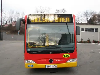 Zakupione autobusy niskopodłogowe marki Mercedes - na zdjęciu autobus oraz budynki