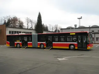 Zakupione autobusy niskopodłogowe marki Mercedes - na zdjęciu autobus oraz budynki