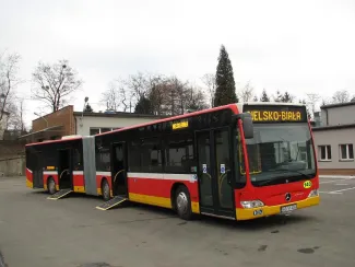 Zakupione autobusy niskopodłogowe marki Mercedes - na zdjęciu autobus oraz budynki