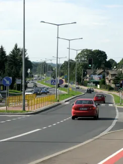 Droga wojewódzka nr 942 w Bielsku-Białej - na zdjęciu fragment drogi, znaki drogowe, świetlenie, pojazdy, budynki oraz zieleń