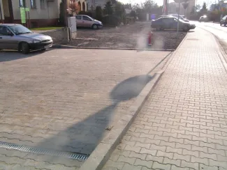 Przebudowa ul. Bestwińskiej w Bielsku-Białej - na zdjęciu fragment chodnika, pojazdy oraz budynki