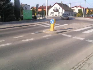 Przebudowa ul. Bestwińskiej w Bielsku-Białej- na zdjęciu fragment drogi, znak drogowy, pojazd oraz budynki