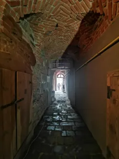 Sień ze sklepieniem i posadzką kamienną. 