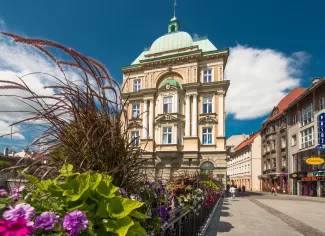 Zdjęcie przedstawiające widok na kamienicę z mostu na rzece Białej.