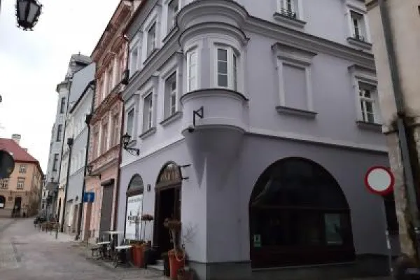 Zdjęcie przedstawiające zabytkową kamienicę na rogu skrzyżowania ulic Rynek, Juliusza Słowackiego oraz Podcienie.
