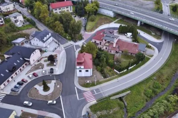 Zdjęcie przedstawiające skrzyżowanie z wjazdem na estakadę, widziane z lotu ptaka, w otoczeniu zabudowy mieszkalnej.