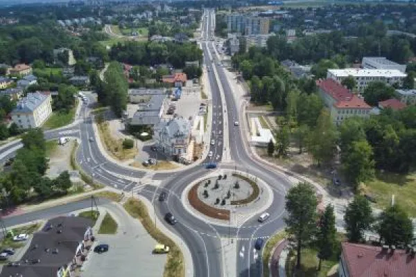 Zdjęcie przedstawiające duże rondo z instalacją pośrodku, widziane z lotu ptaka, otoczone miejską zabudową.