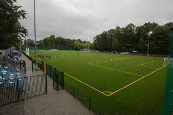 Zdjęcie przedstawiające boisko piłkarskie ze sztuczną nawierzchnią otoczone drzewami i trybunami przy ul. Jaworzańskiej w Bielsku-Białej.