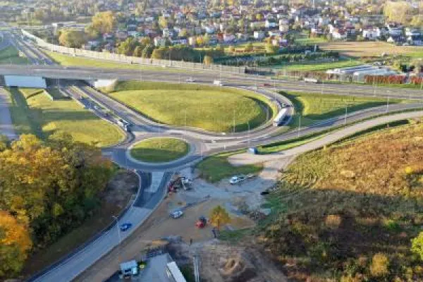 Zdjęcie przedstawiające węzeł drogowy z rondem i estakadami widziany z lotu ptaka.